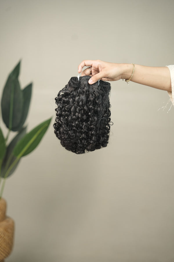 D'HAIR Halo Kinky Curl 20-inch weft. Compact, overlapping curls with an irregular, textured outline.