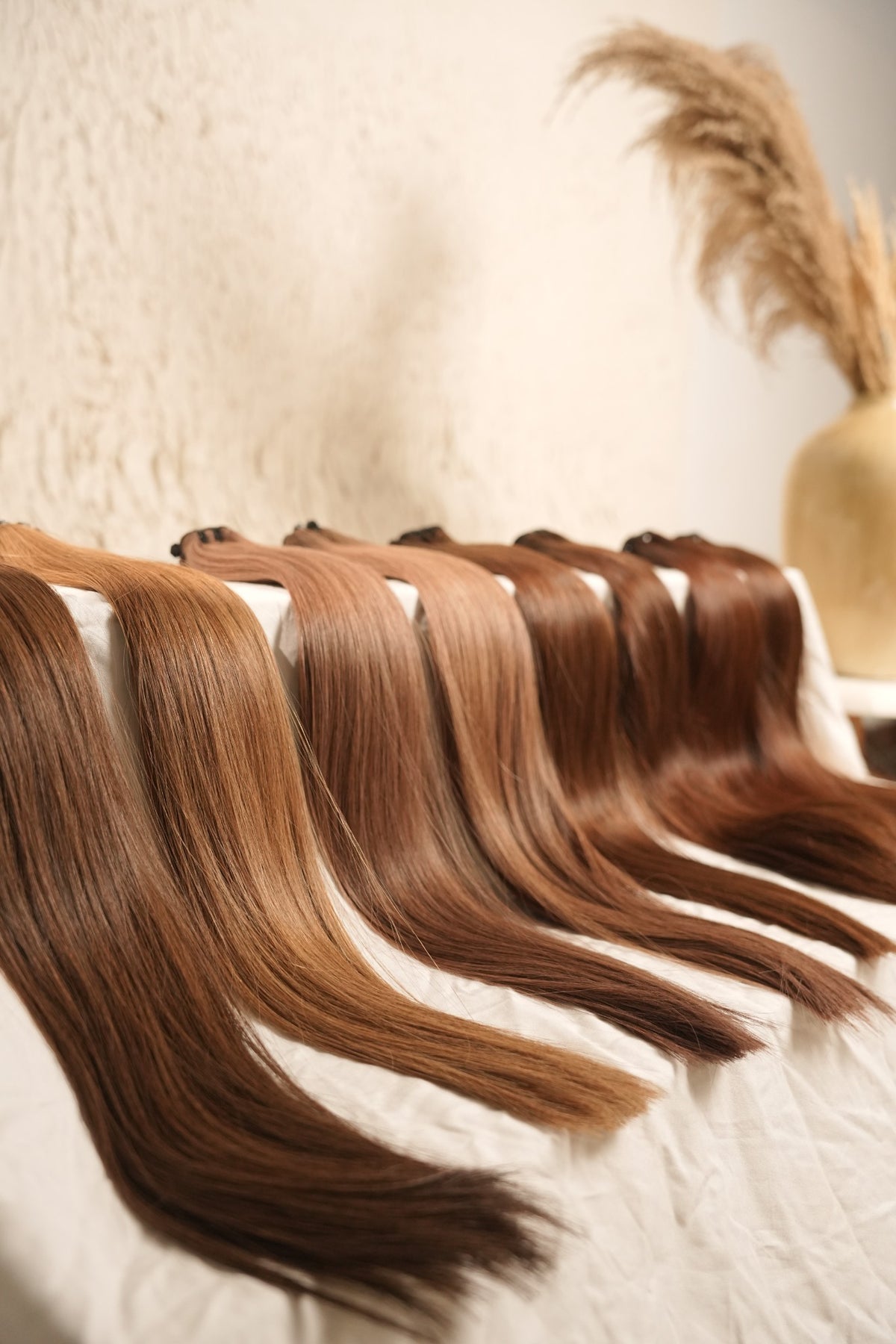 D’HAIR straight wefts in a range of brown and lighter shades, photographed in the studio.